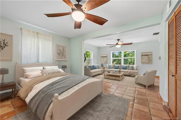 a spacious bedroom with a bed and glass windows