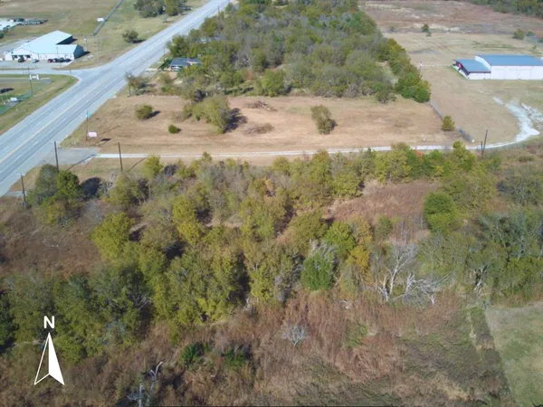 a view of a dry yard with wooden fence