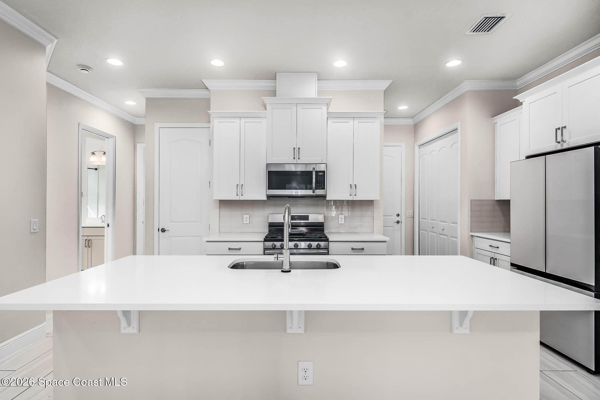 7929 Cache Crk Lane Melbourne, FL 32940 - Photo 13 of 45 a kitchen with stainless steel appliances a refrigerator sink stove microwave and cabinets