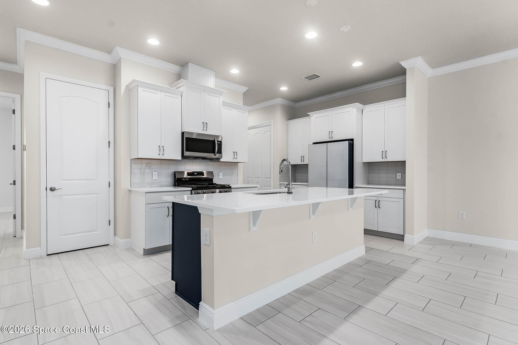 7929 Cache Crk Lane Melbourne, FL 32940 - Photo 14 of 45 a kitchen with stainless steel appliances a refrigerator sink and microwave