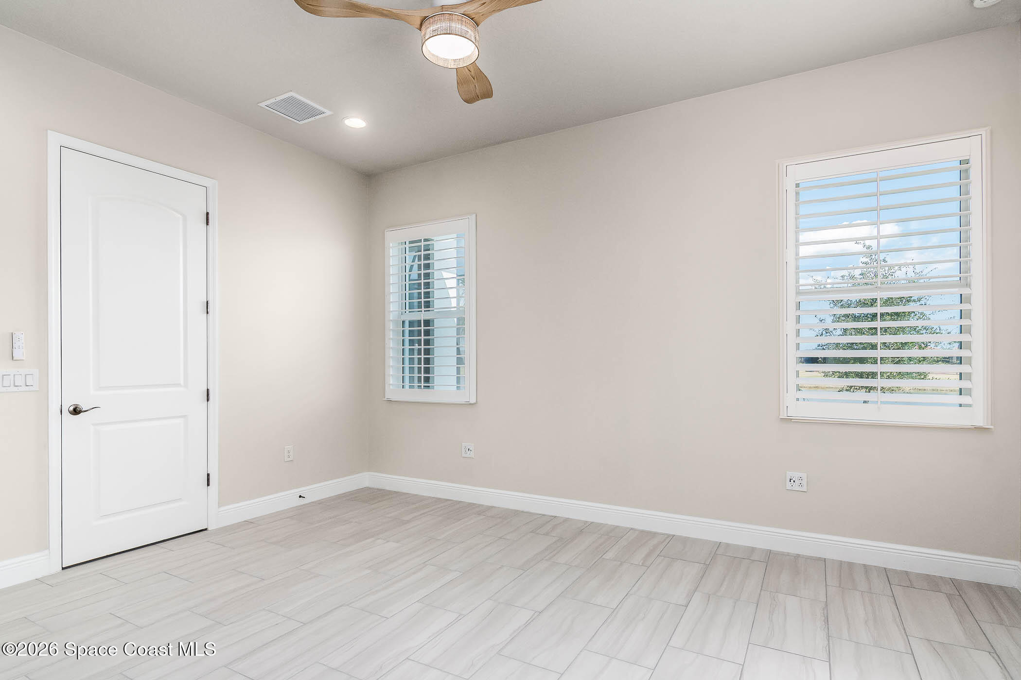 7929 Cache Crk Lane Melbourne, FL 32940 - Photo 19 of 45 an empty room with wooden floor and windows