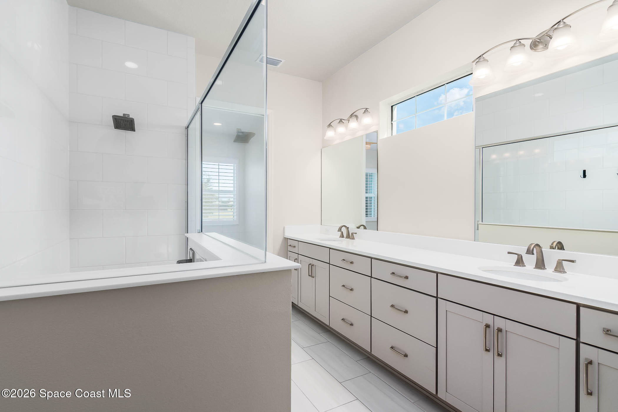 7929 Cache Crk Lane Melbourne, FL 32940 - Photo 30 of 45 a bathroom with a double vanity sink and mirror