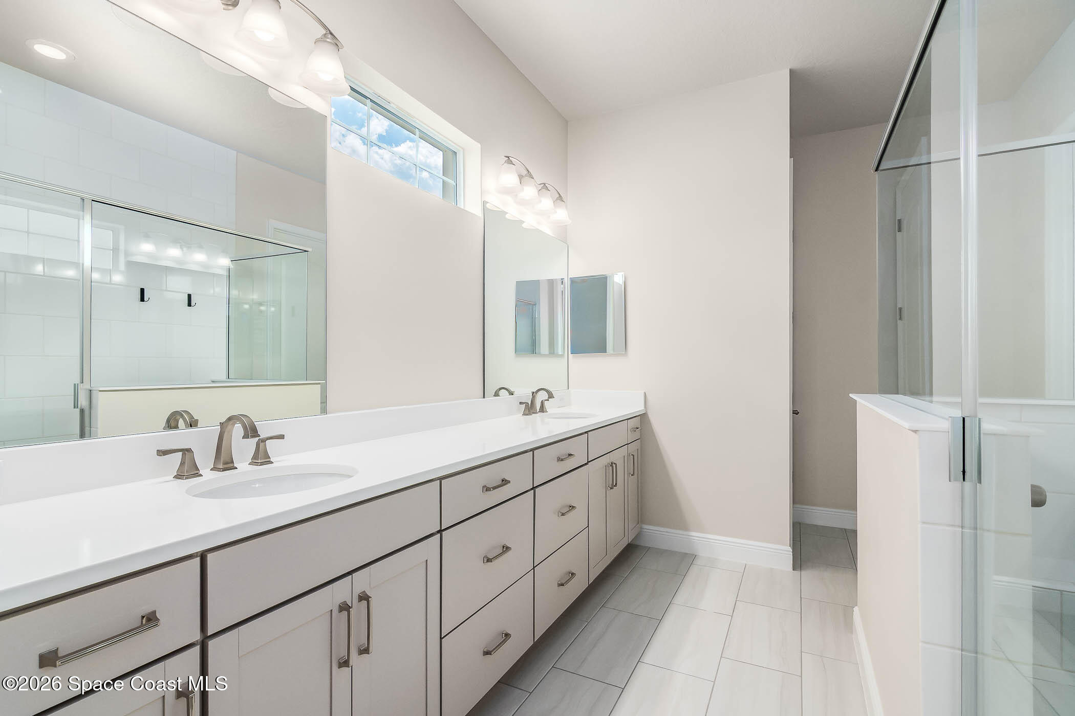 7929 Cache Crk Lane Melbourne, FL 32940 - Photo 7 of 45 a bathroom with a double vanity sink and mirror