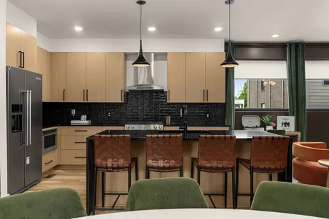 a kitchen with stainless steel appliances granite countertop a stove a refrigerator a kitchen island a sink cabinets and a refrigerator