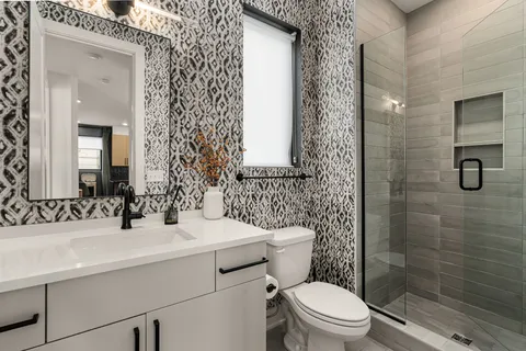 a bathroom with a sink a toilet and shower