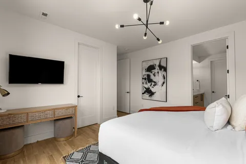 a bedroom with a bed and a flat screen tv