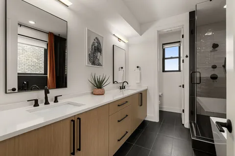 a bathroom with a double vanity sink a mirror and a shower