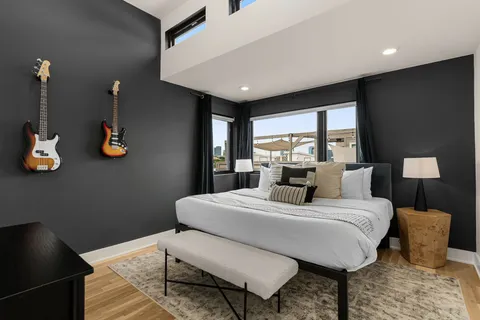 a bedroom with a bed a table and painting on the wall