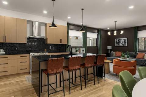 a kitchen with stainless steel appliances granite countertop a stove a sink a dining table chairs and view of living room