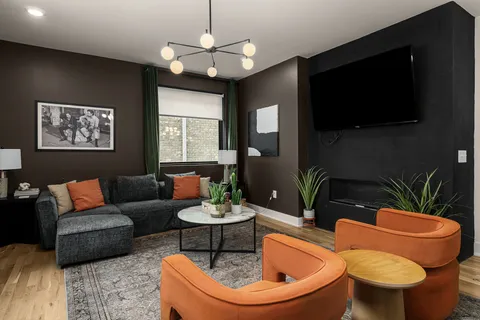 a living room with furniture a flat screen tv and kitchen view