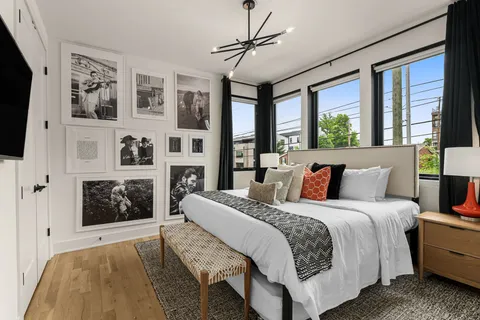 a spacious bedroom with a bed wooden floor and window