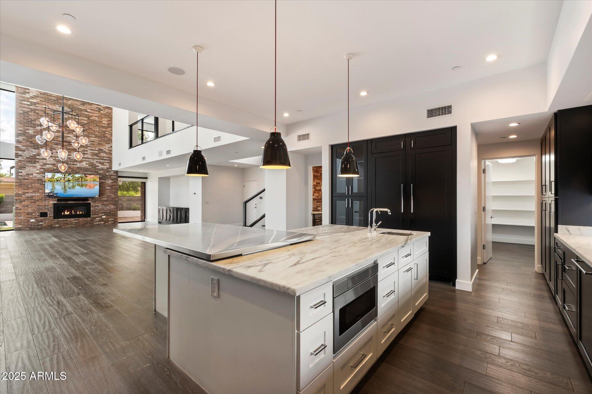 4525 North 36th Way Phoenix, AZ 85018 - Photo 13 of 40 a large kitchen with stainless steel appliances kitchen island a large counter top and a wooden floors