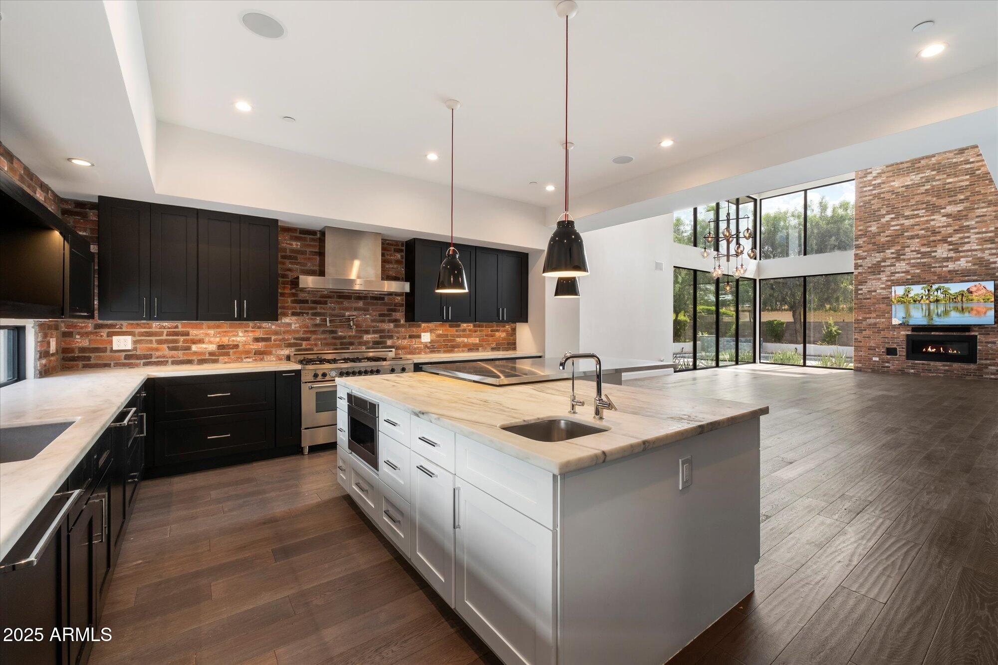 4525 North 36th Way Phoenix, AZ 85018 - Photo 14 of 40 a kitchen with stainless steel appliances granite countertop a sink a stove and a wooden floors