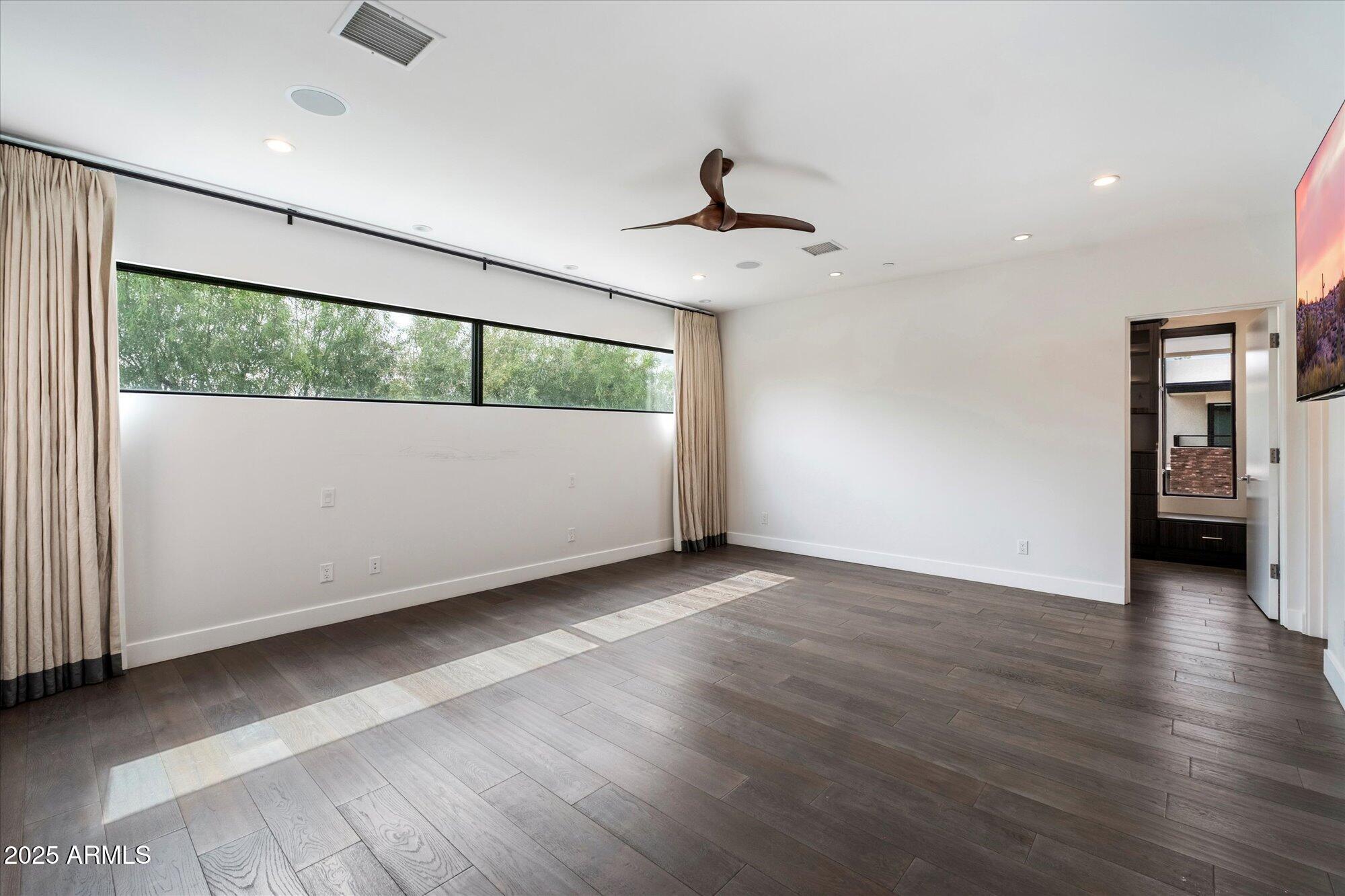 4525 North 36th Way Phoenix, AZ 85018 - Photo 19 of 40 an empty room with wooden floor and windows