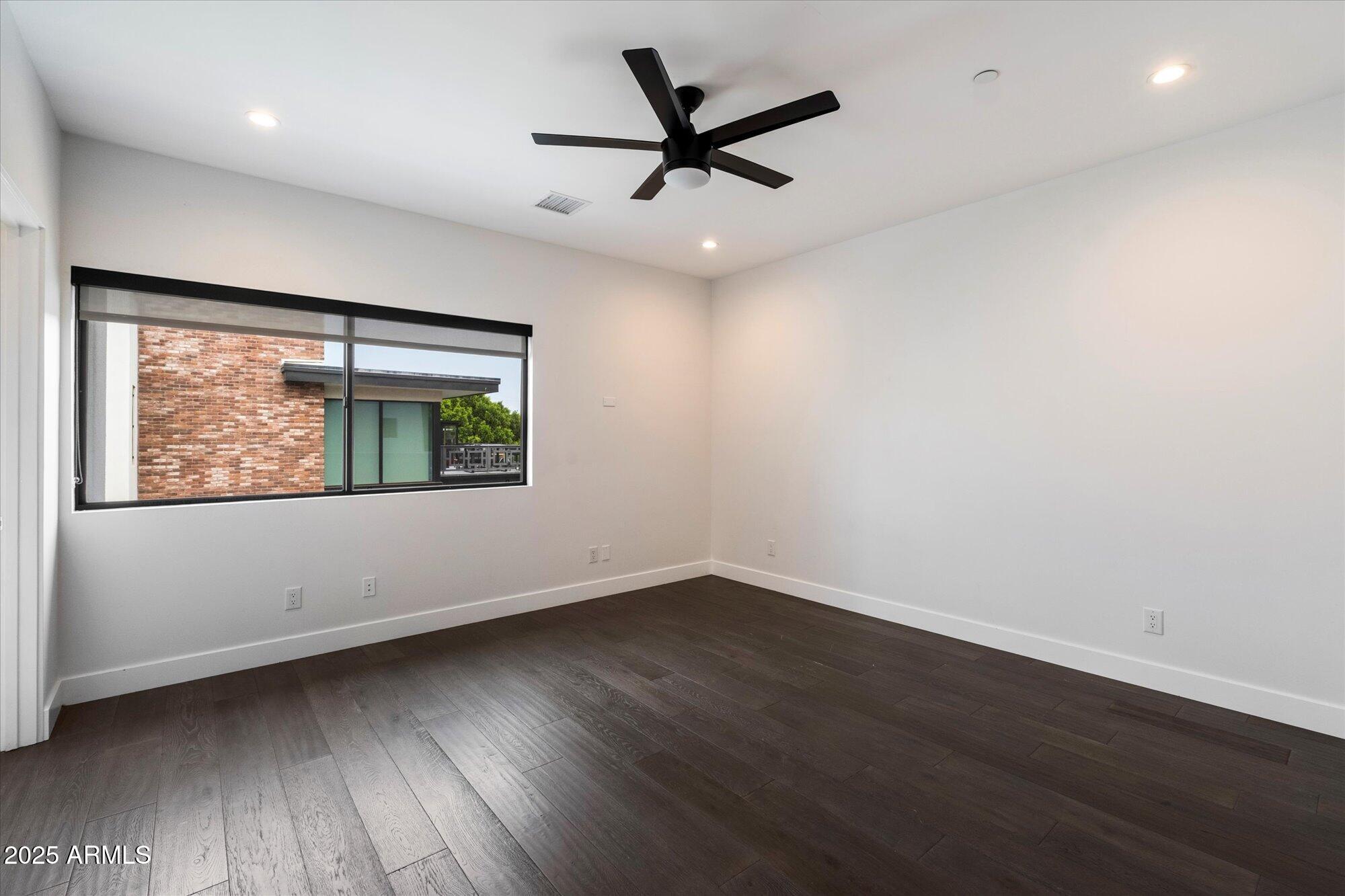4525 North 36th Way Phoenix, AZ 85018 - Photo 27 of 40 an empty room with wooden floor and windows