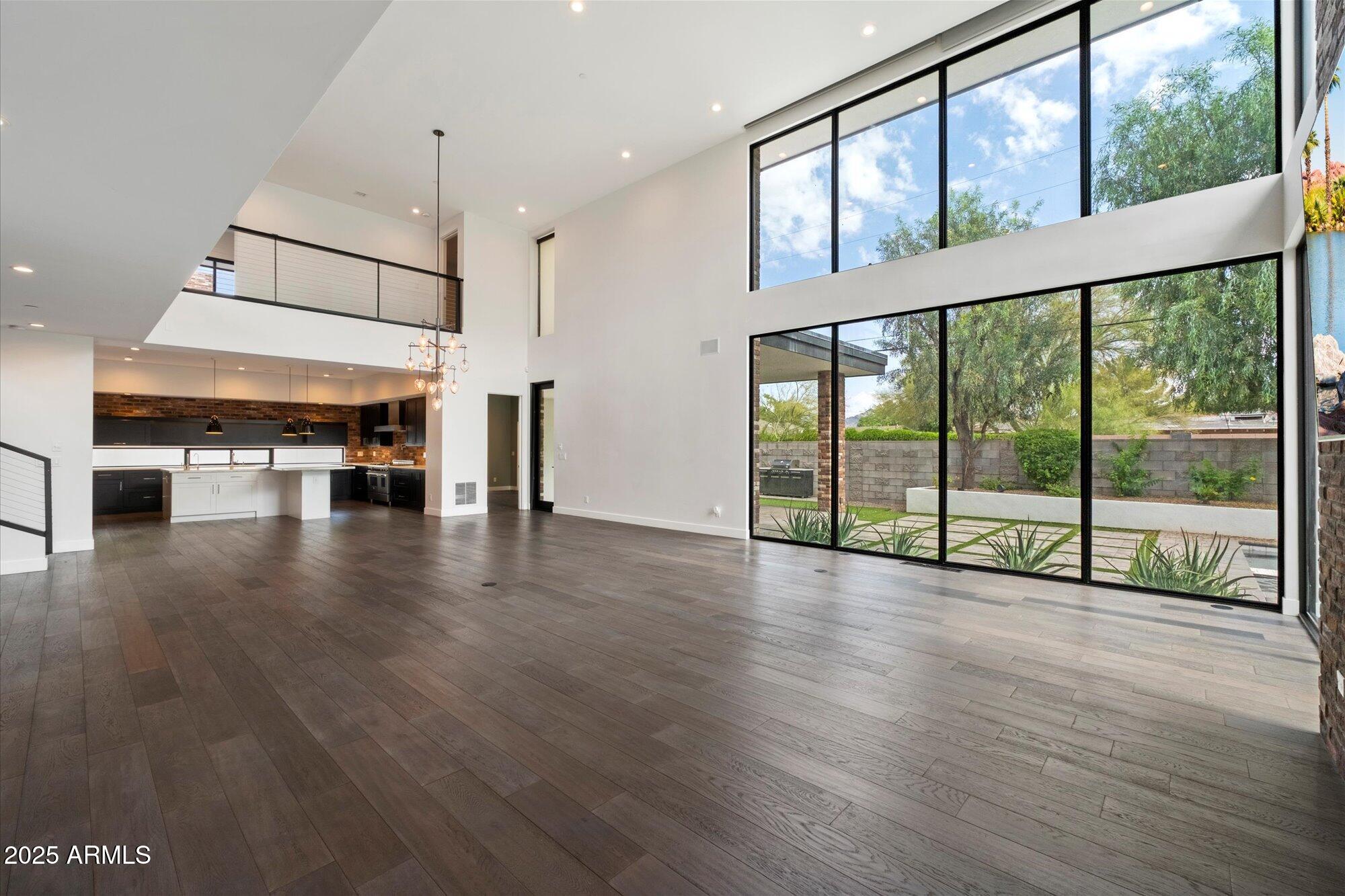 4525 North 36th Way Phoenix, AZ 85018 - Photo 8 of 40 a view of an empty room with wooden floor and a large window