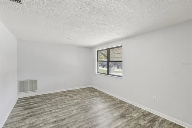 a view of an empty room with a window and fireplace