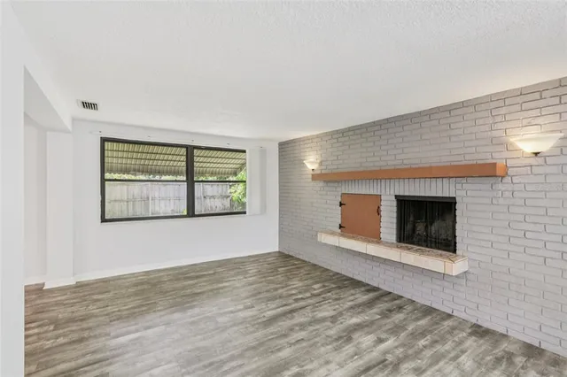 a kitchen with a stove a sink and white cabinets with wooden floor