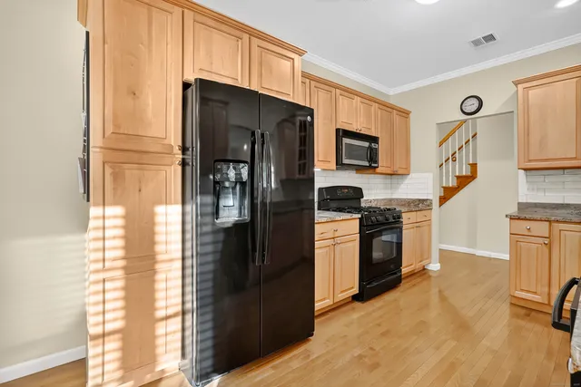 a kitchen with stainless steel appliances granite countertop a stove refrigerator and microwave