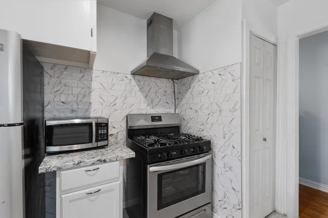 a kitchen with stainless steel appliances a stove and a microwave