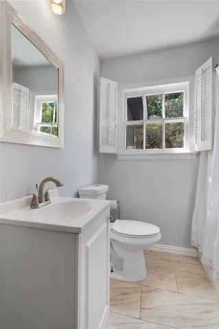 a bathroom with a sink toilet and a window