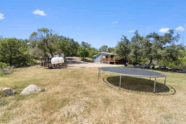 a view of a swimming pool with a bench and trees around