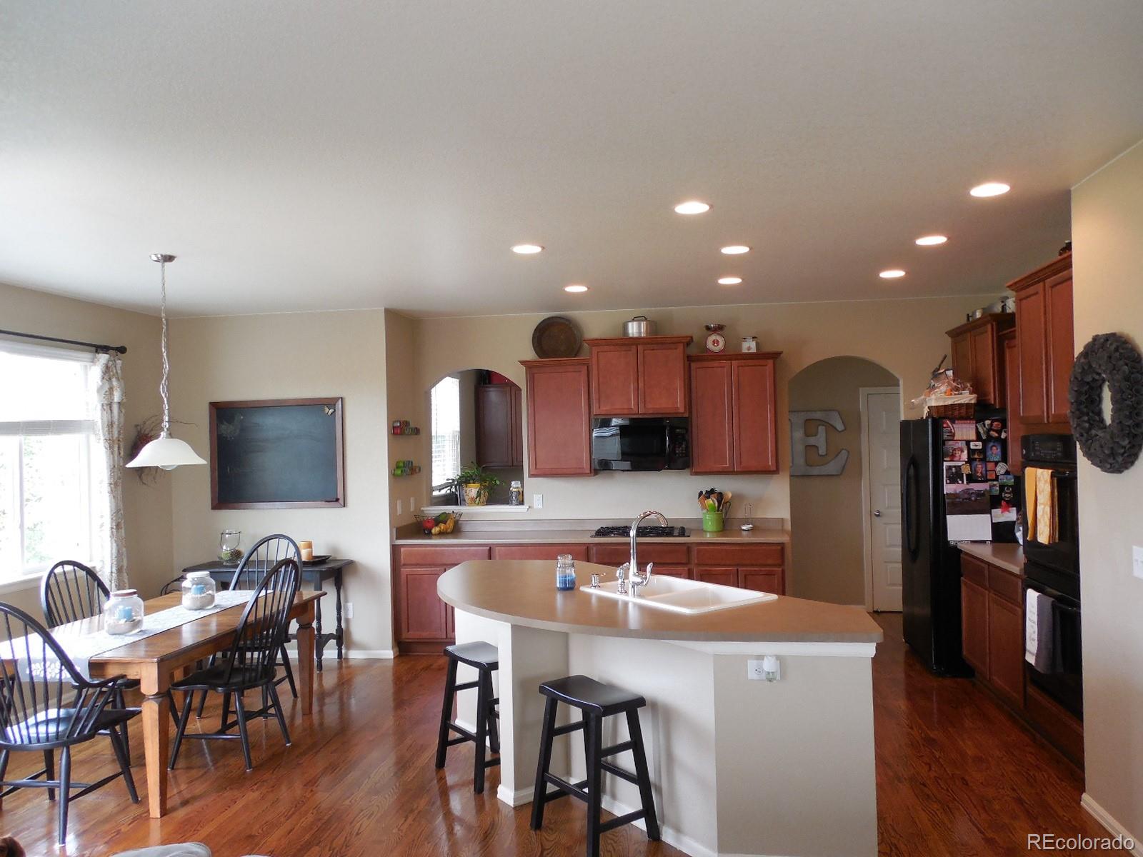 4455 Bramble Road Frederick, CO 80504 - Photo 8 of 20 a kitchen with stainless steel appliances kitchen island granite countertop a dining table and chairs