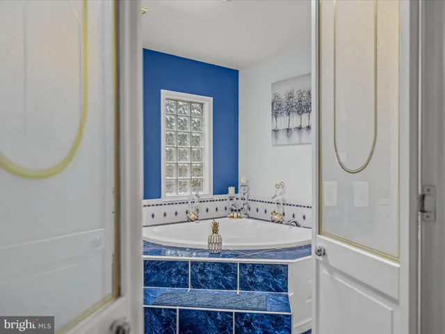 a bathroom with a granite countertop bathtub a mirror and a shower
