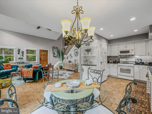 a living room with kitchen island furniture and a chandelier