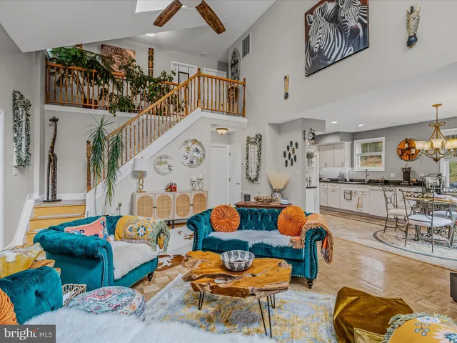 a living room with furniture kitchen view and a wooden floor