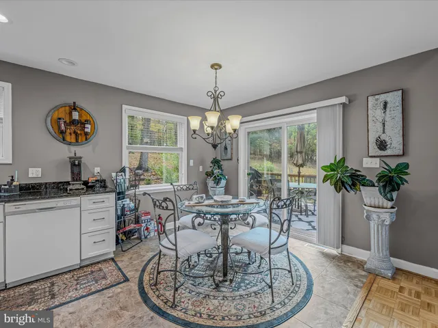 a dining room with furniture potted plants and a chandelier