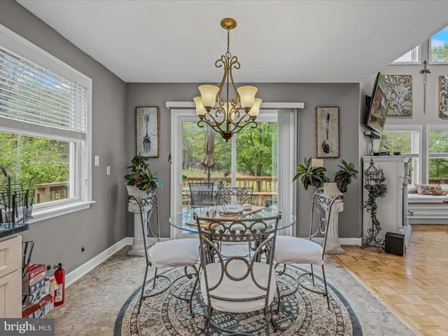 a dining room with furniture a chandelier and wooden floor