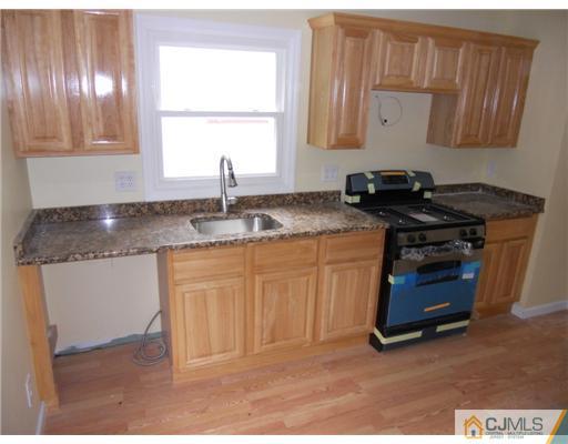 473 Chain O' Hills Road Colonia, NJ 07067 - Photo 2 of 10 a kitchen with granite countertop a sink stove and cabinets