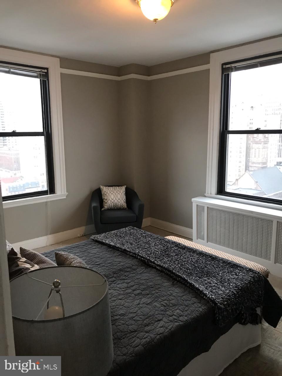 2031 Locust Street, Unit 1404 Philadelphia, PA 19103 - Photo 8 of 20 a bed sitting in a bedroom next to a window