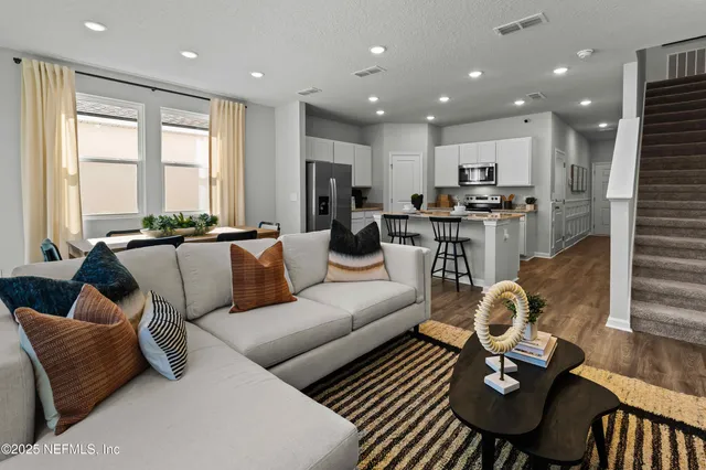 a living room with furniture a rug and a flat screen tv