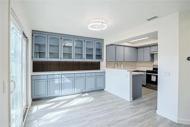 a kitchen with a refrigerator and white cabinets