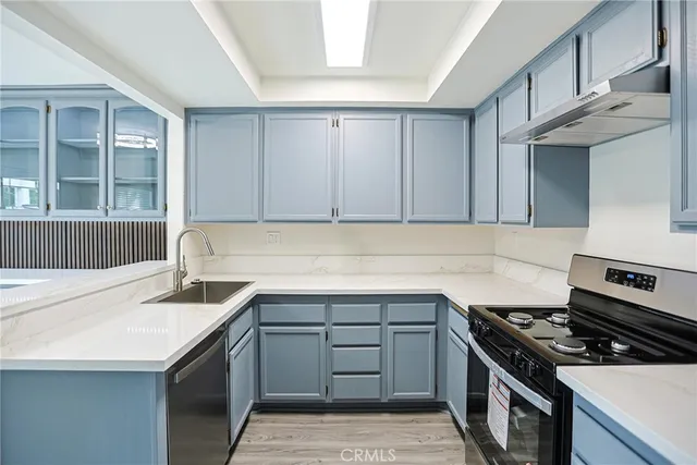 a kitchen with granite countertop a sink stove and cabinets