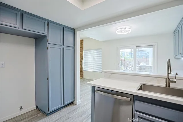 a view with granite countertop a sink cabinets and a window