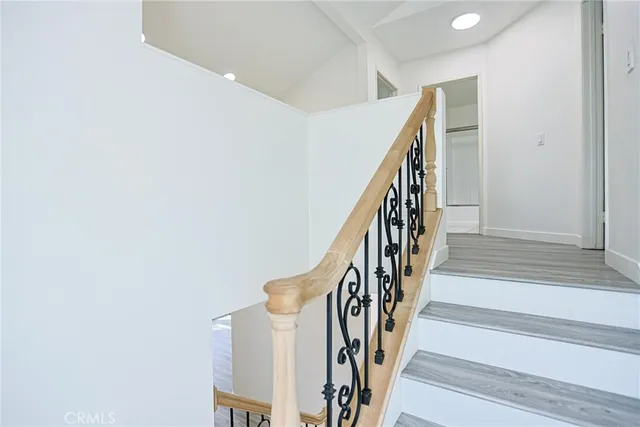 a view of staircase with wooden floor and white walls