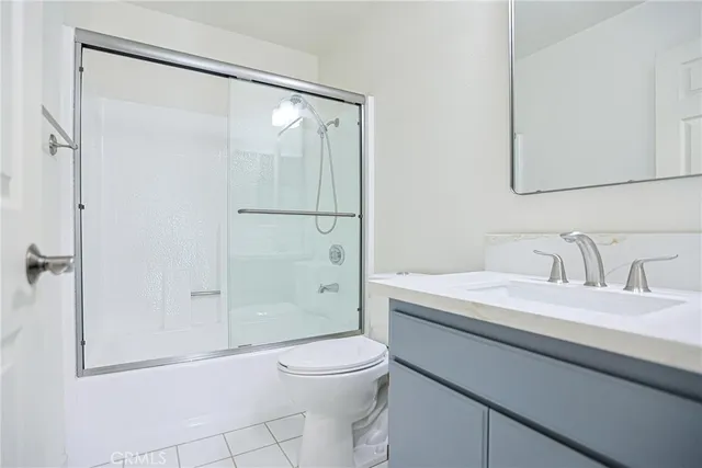 a bathroom with a granite countertop sink a toilet and shower