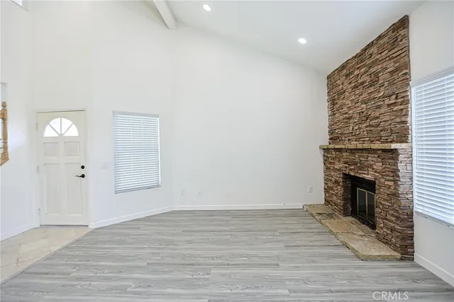 a view of empty room with wooden floor and fireplace