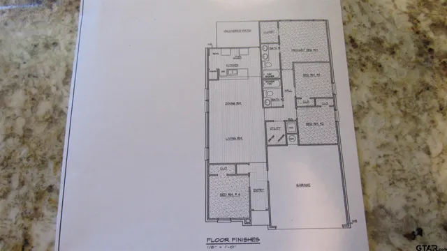 a view of a white house next to a yard with large trees