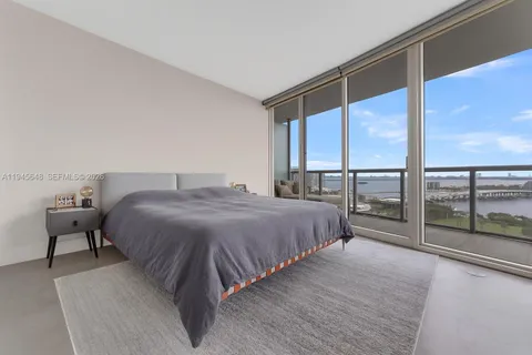 a spacious bedroom with a bed and a large window