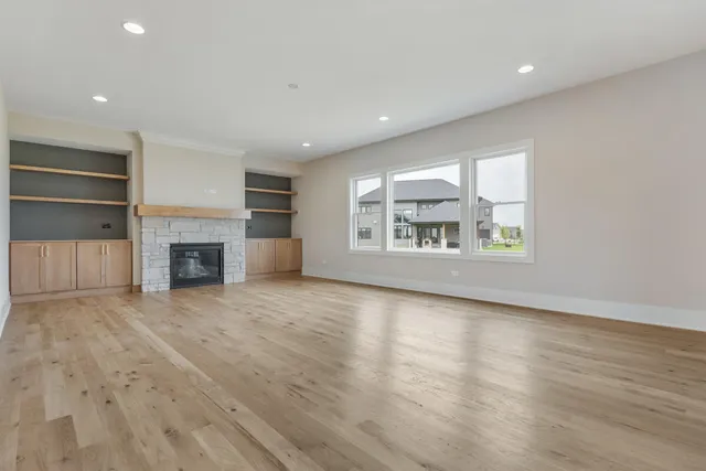 an empty room with a fireplace and wooden floor