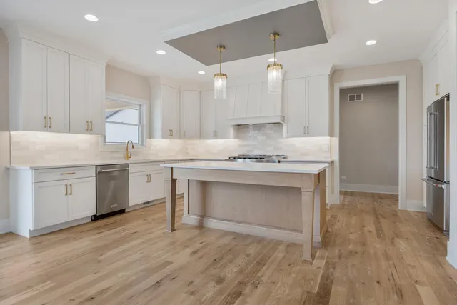a kitchen with a sink cabinets and wooden floor