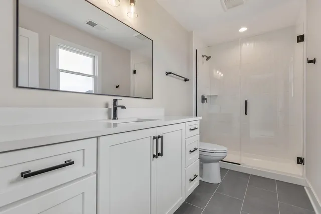 an empty room with chandelier fan and windows