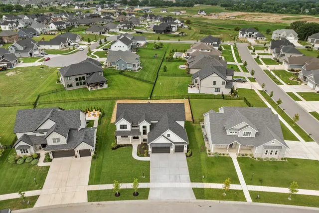 an aerial view of a house with a garden and lake view