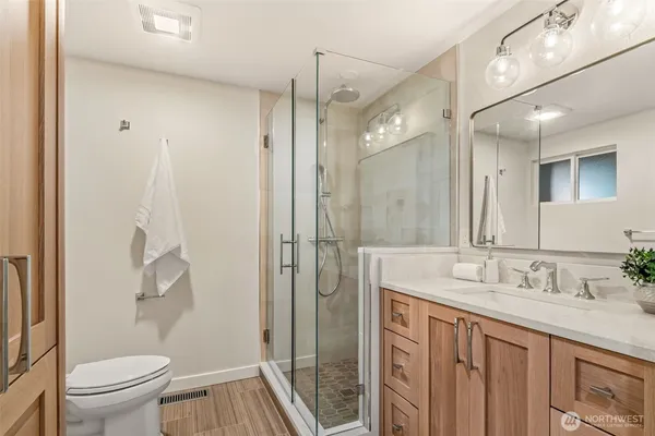 a bathroom with a granite countertop sink a toilet and shower