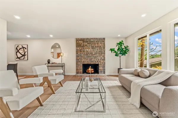 a living room with furniture a fireplace and a large window