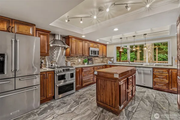 a kitchen with stainless steel appliances granite countertop a sink stove and refrigerator